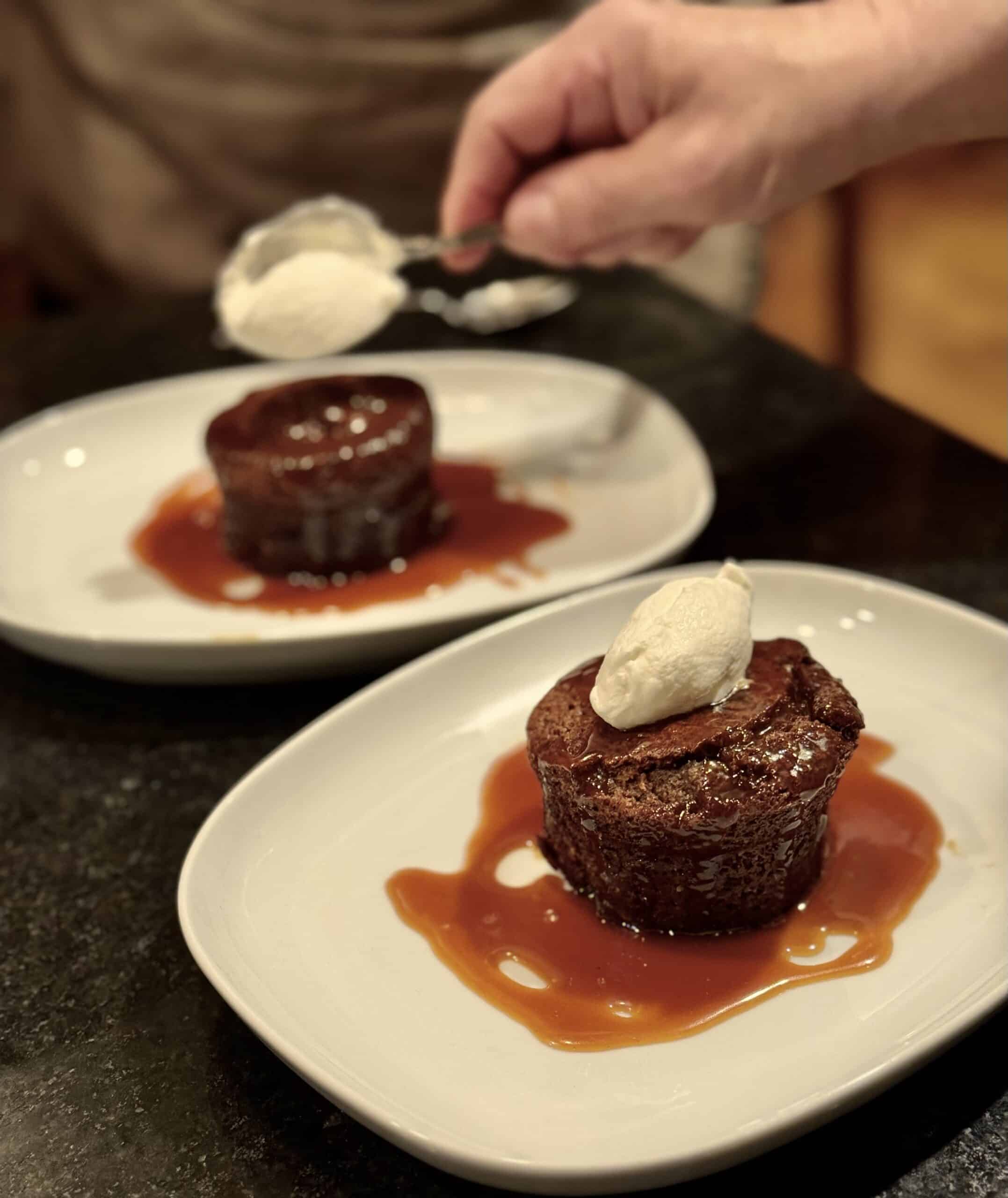 Delicious gourmet desserts with rich sauce and whipped cream, perfect for special events.