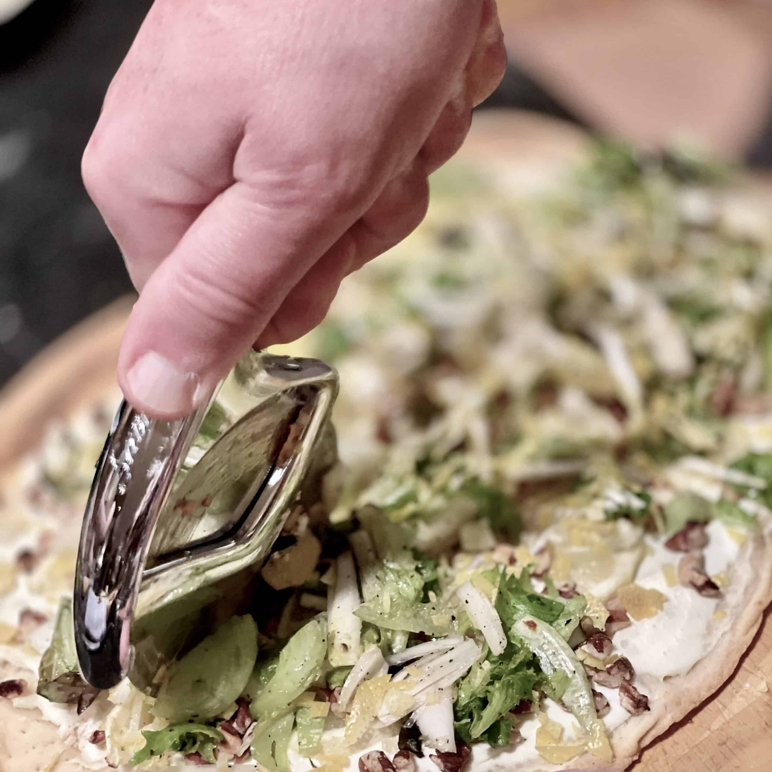Gourmet vegetable pizza with fresh greens, herbs, and cheese, ready to serve at Odyssey Events.