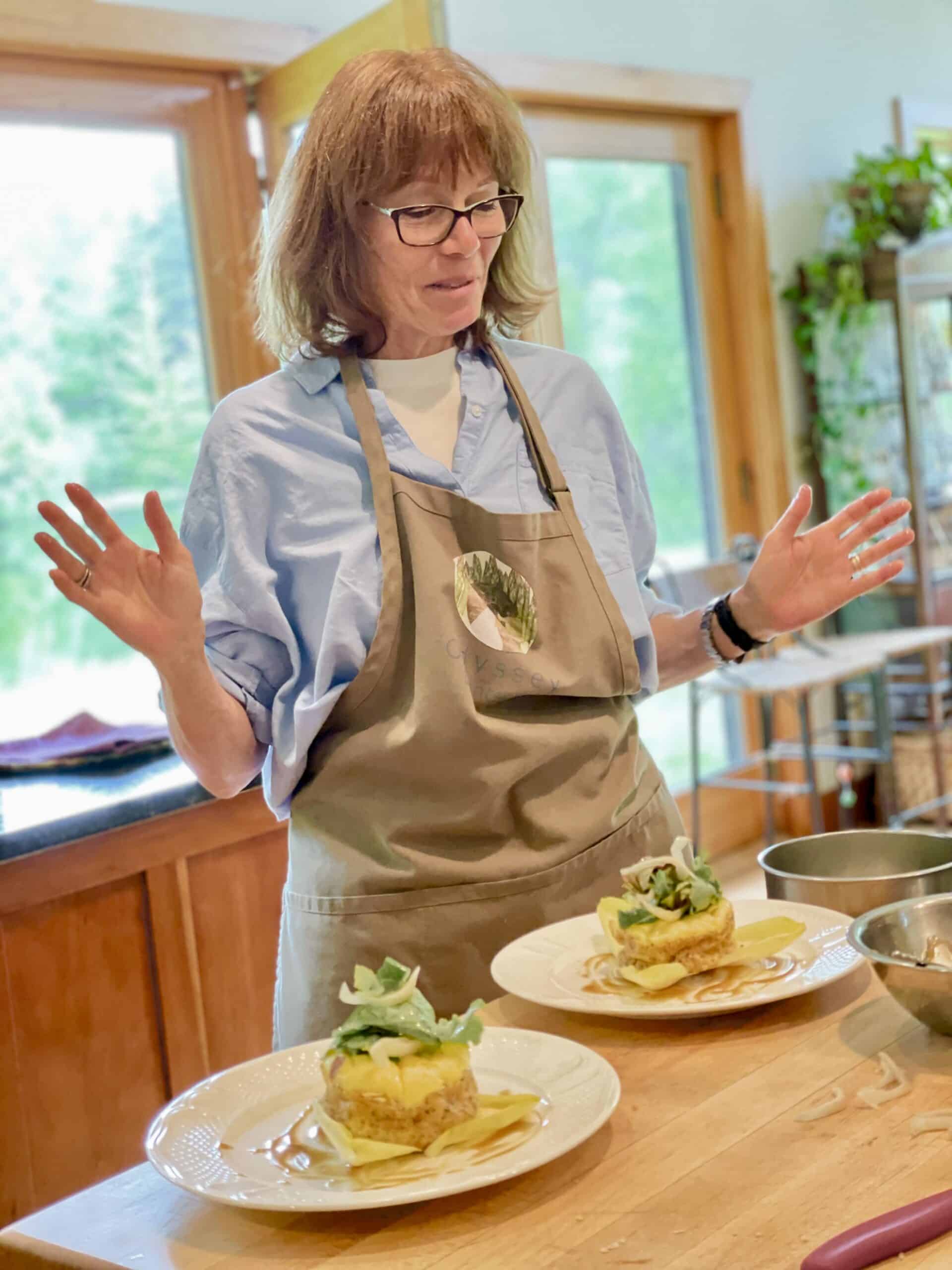 Chef presenting gourmet dishes with fresh ingredients and artistic plating.