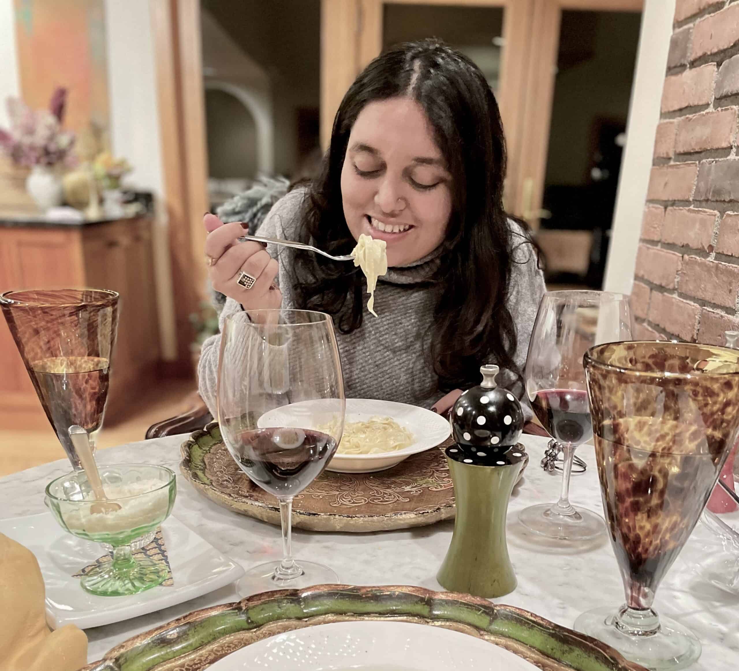 Woman enjoying pasta dinner at Odyssey Events restaurant.