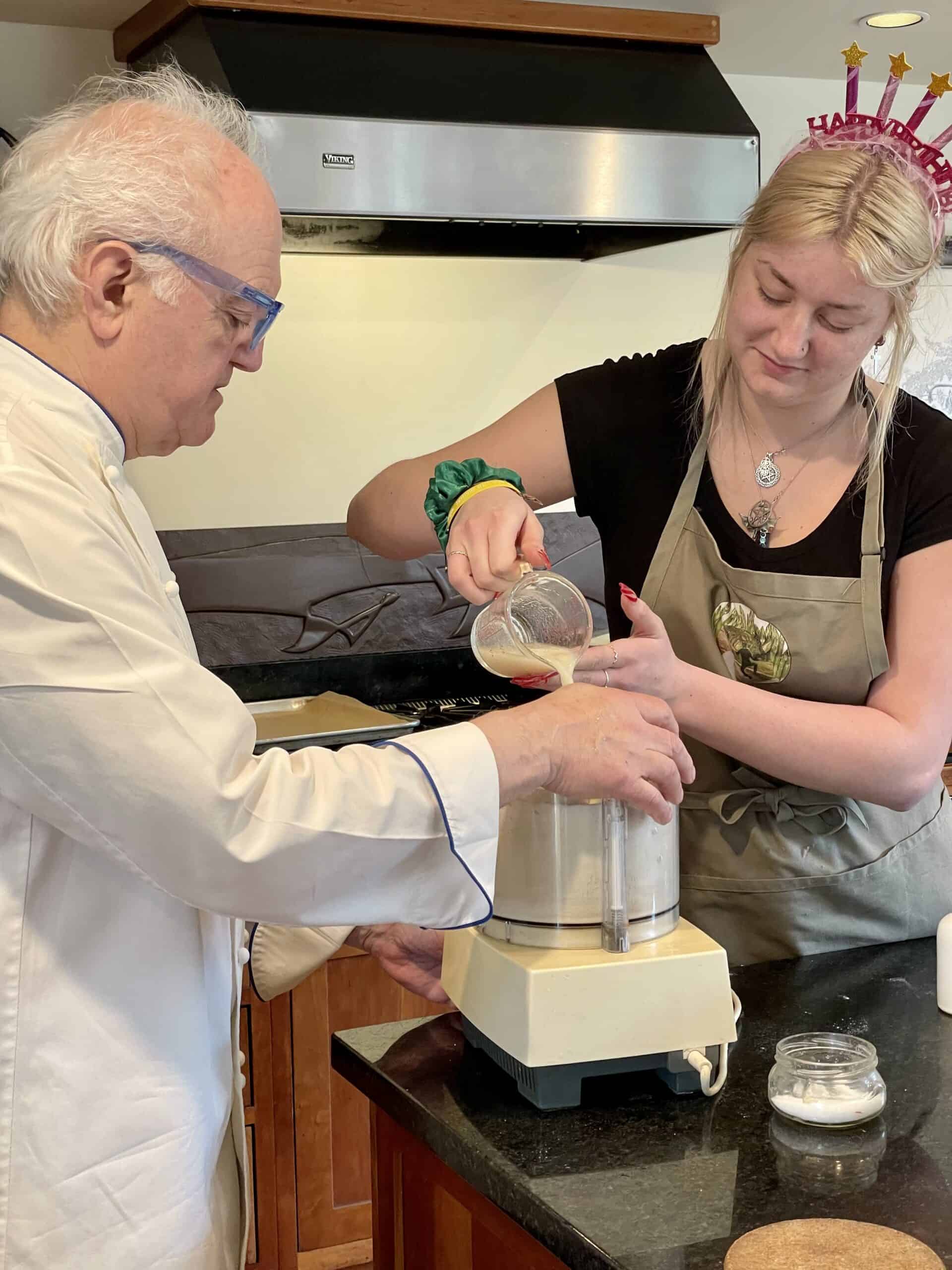 Chef and young woman baking together at a cooking class.
