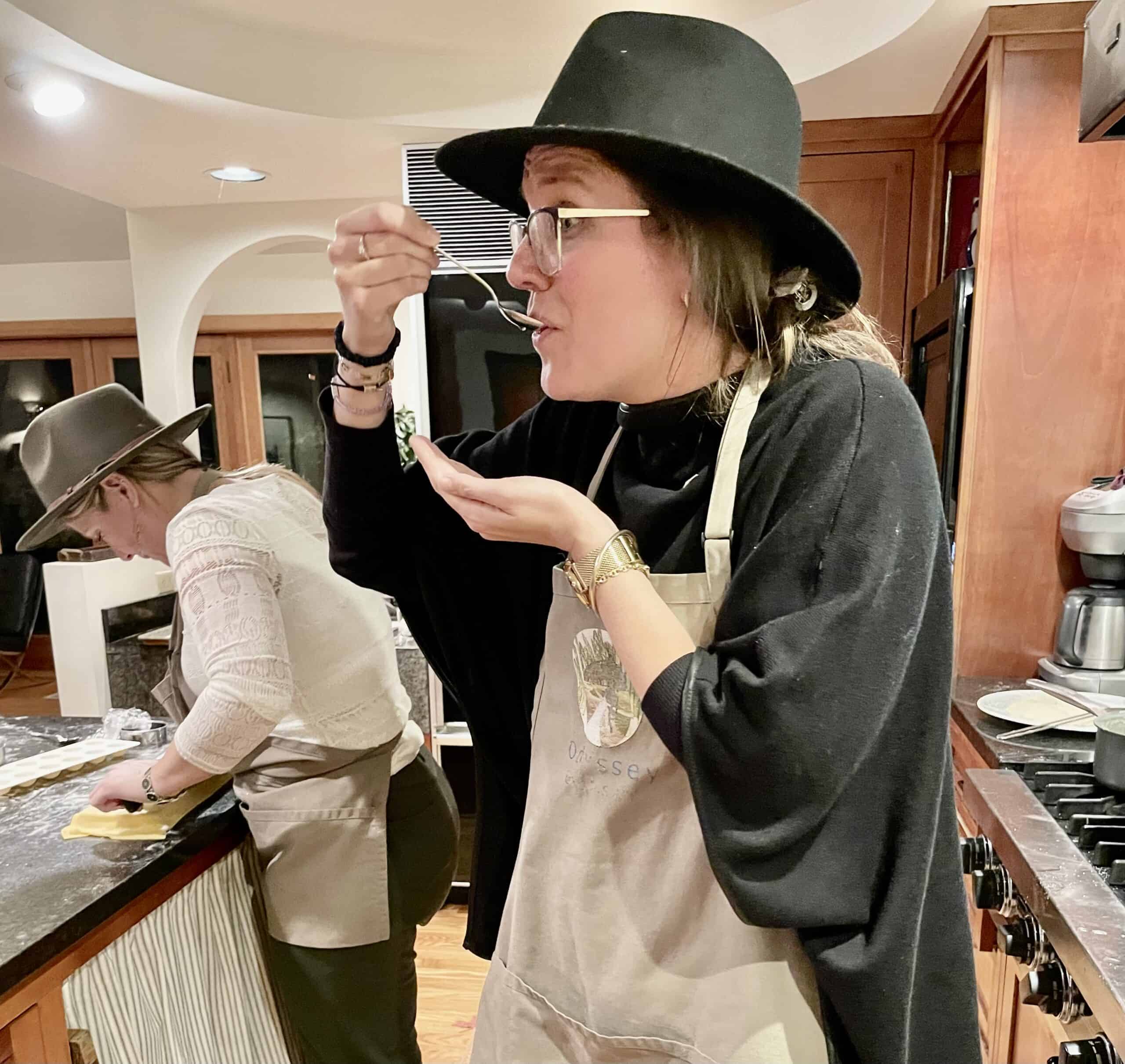 Woman tasting chocolate at Odyssey Events, wearing a black hat and apron.