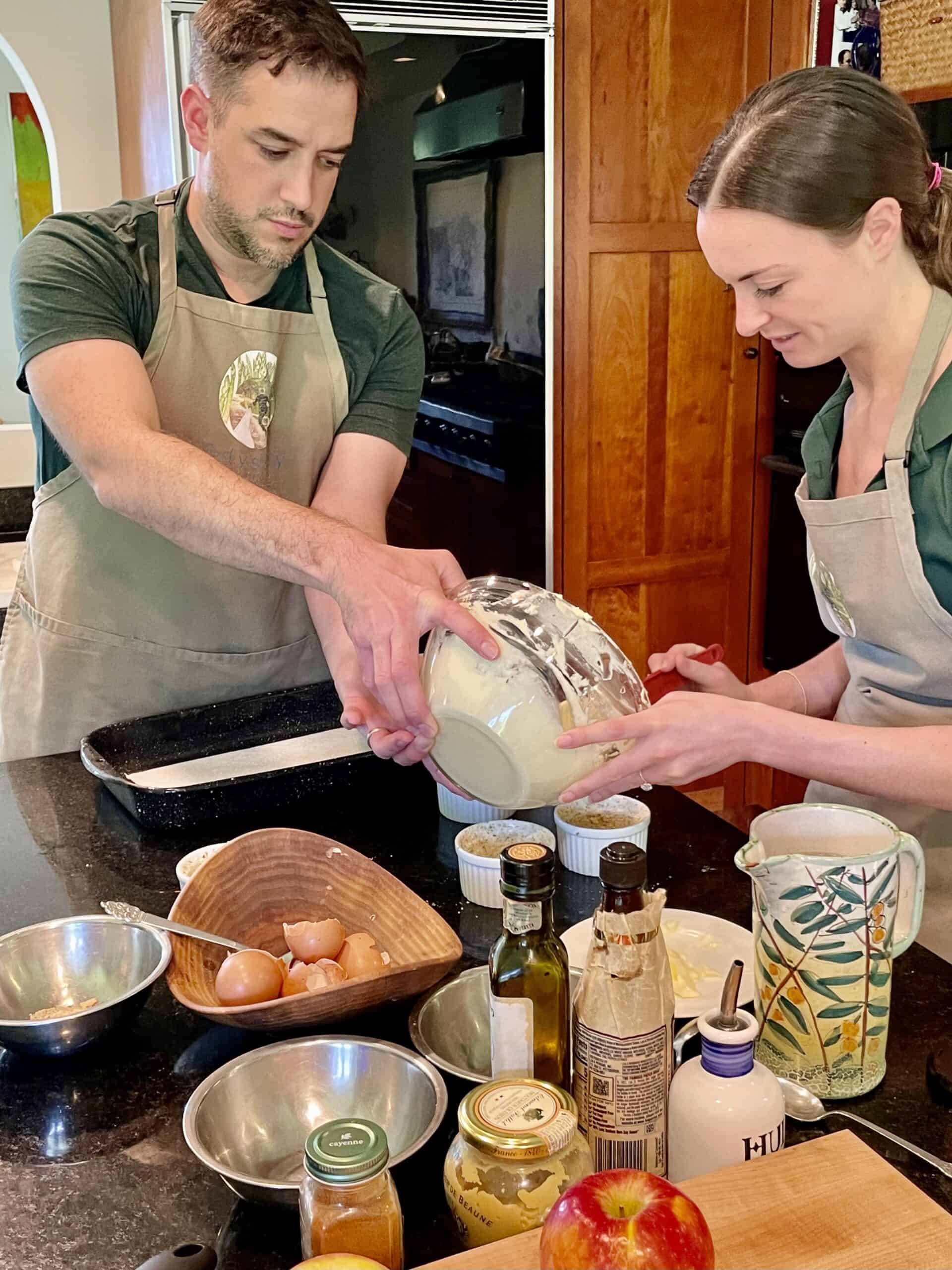 Man and woman preparing food together in a cozy kitchen setting.