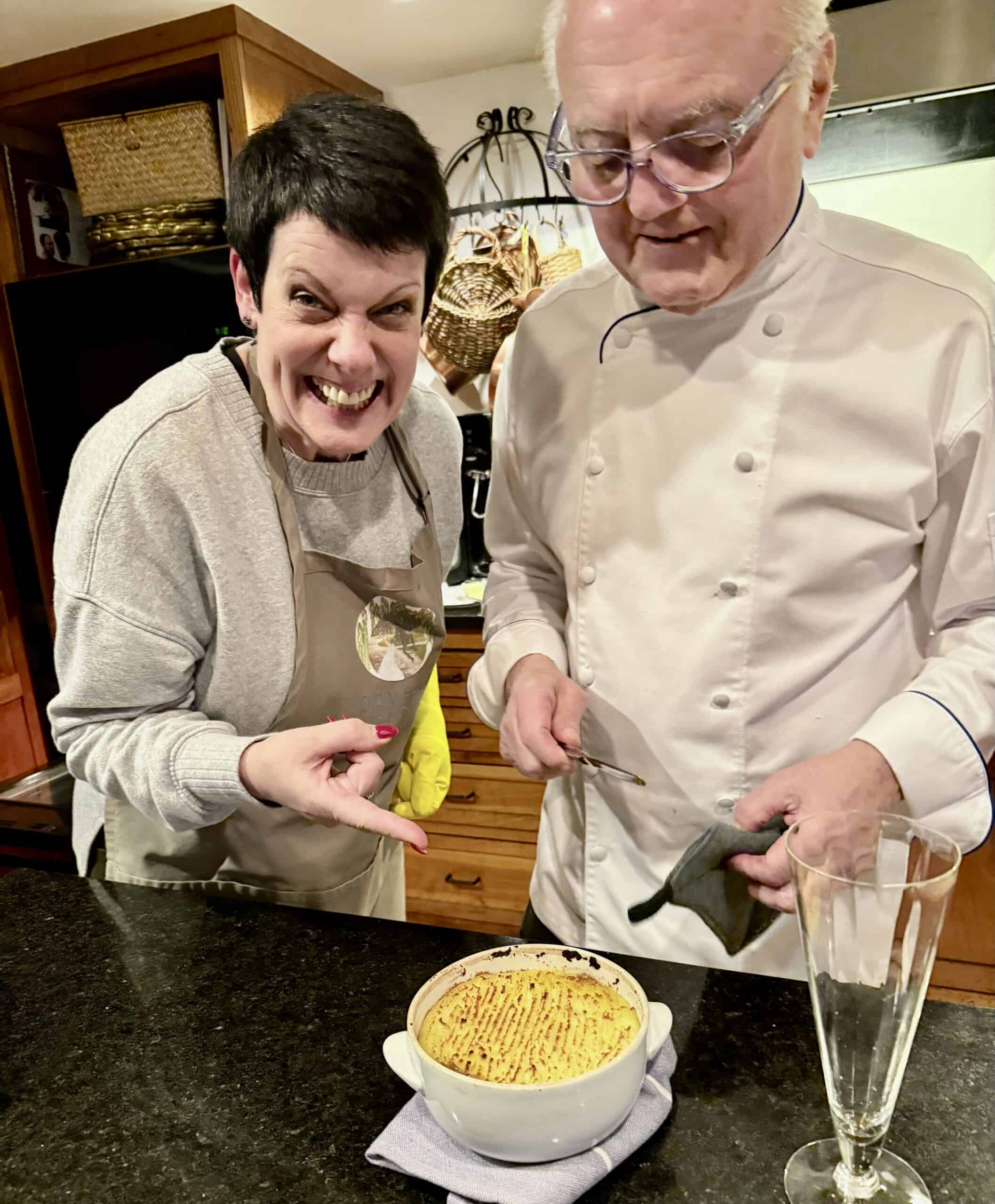 Two people enjoying a cooking class with a baked dish at Odyssey Events.