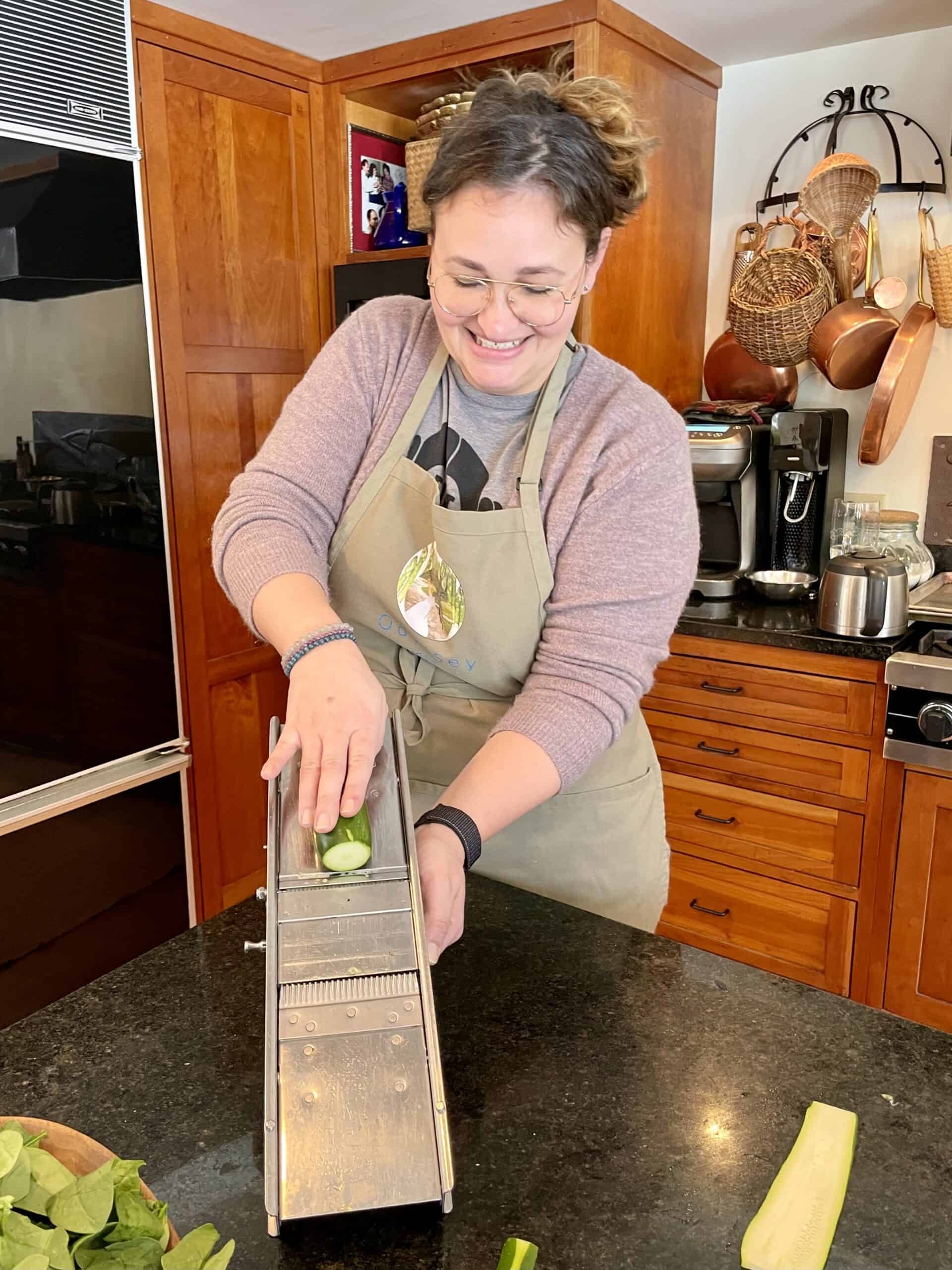 Woman grating zucchini in a cozy kitchen for event catering.