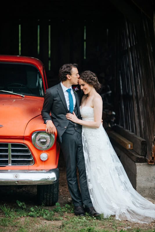 Wedding couple with vintage red truck at Odyssey Events venue.