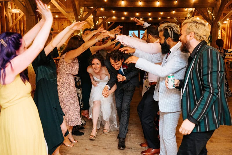 Guests celebrating at a wedding reception with lively dancing and joyful atmosphere.