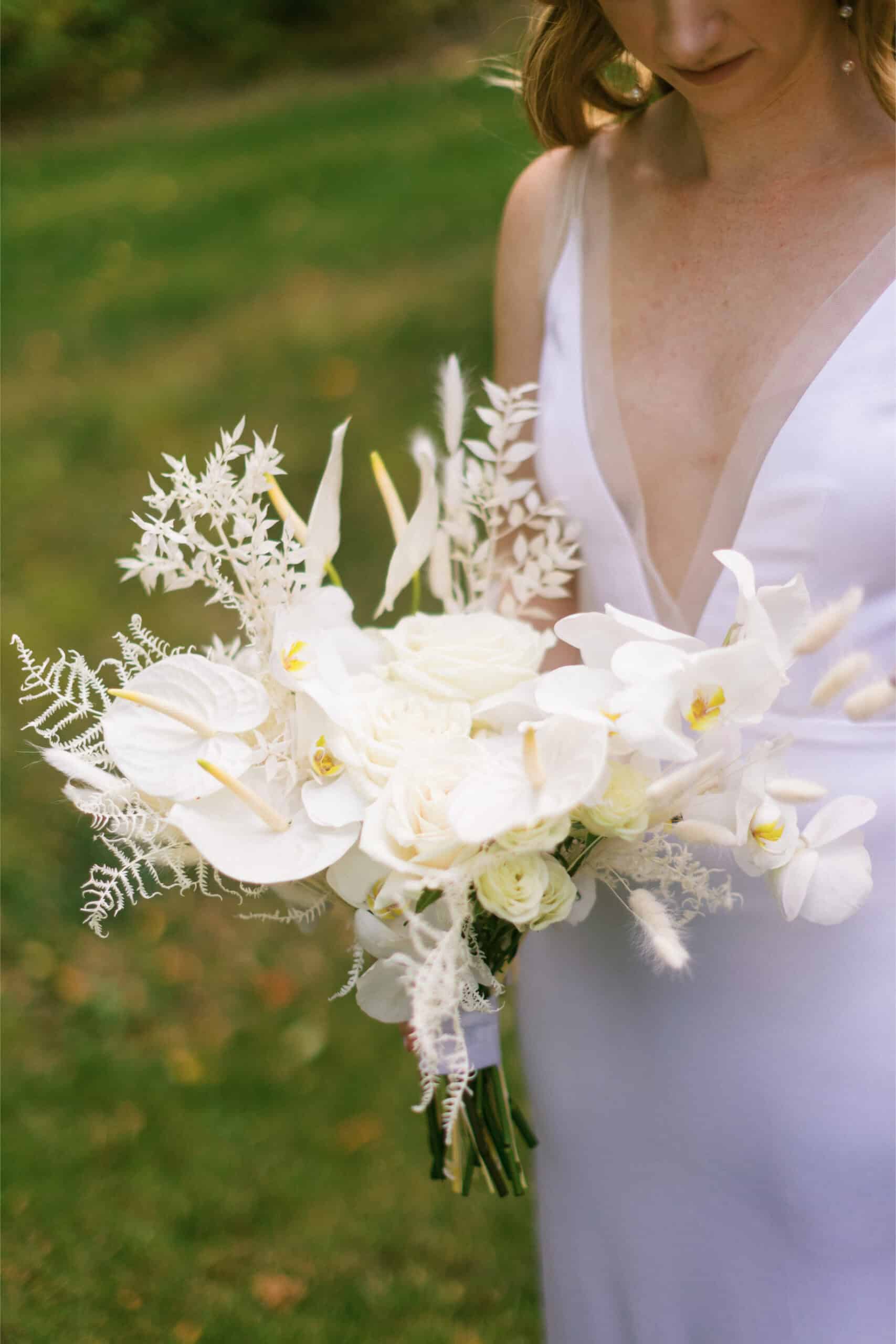 Beautiful white bridal bouquet with orchids and greenery for wedding ceremonies.