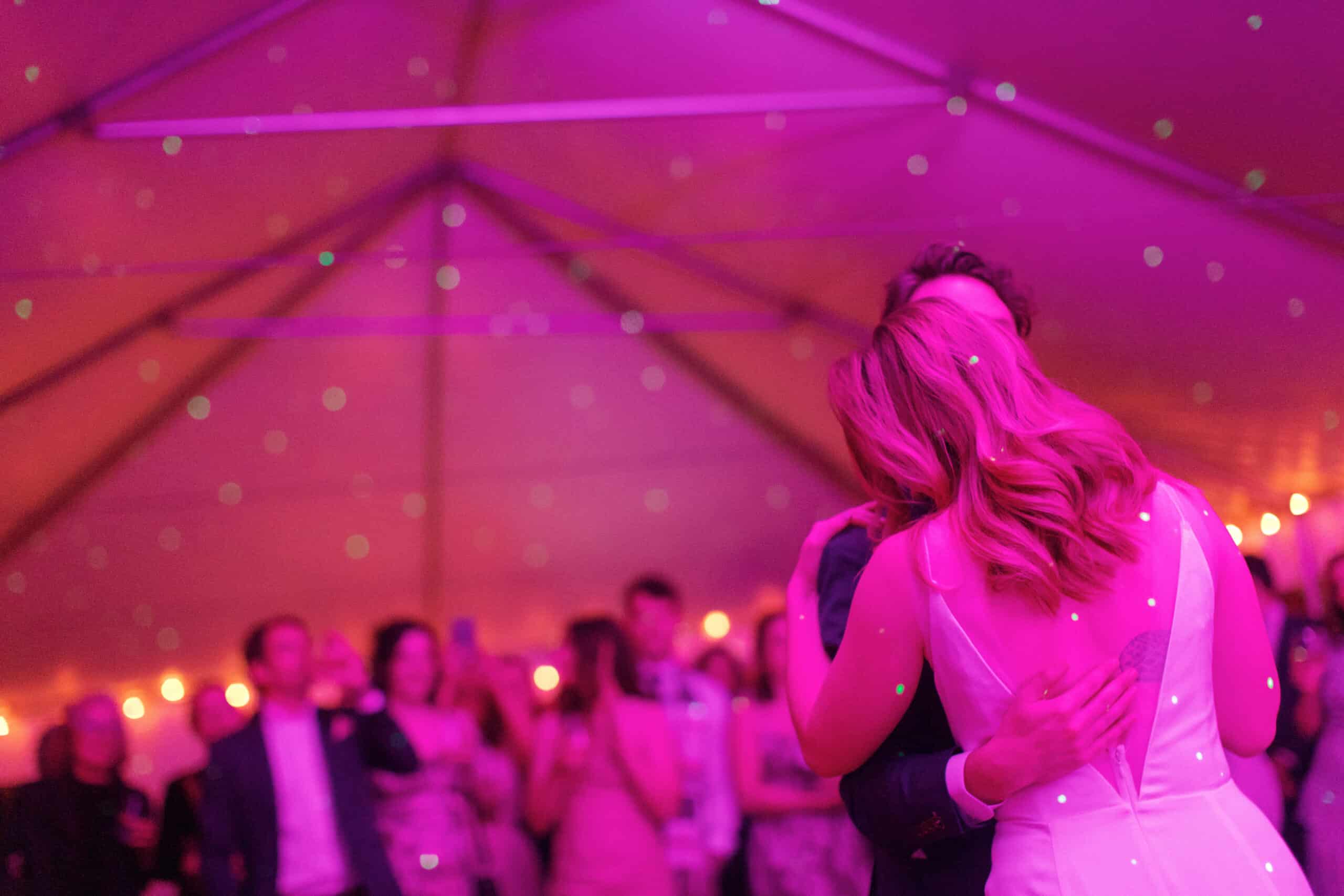 Elegant wedding dance under colorful lighting at Odyssey Events.