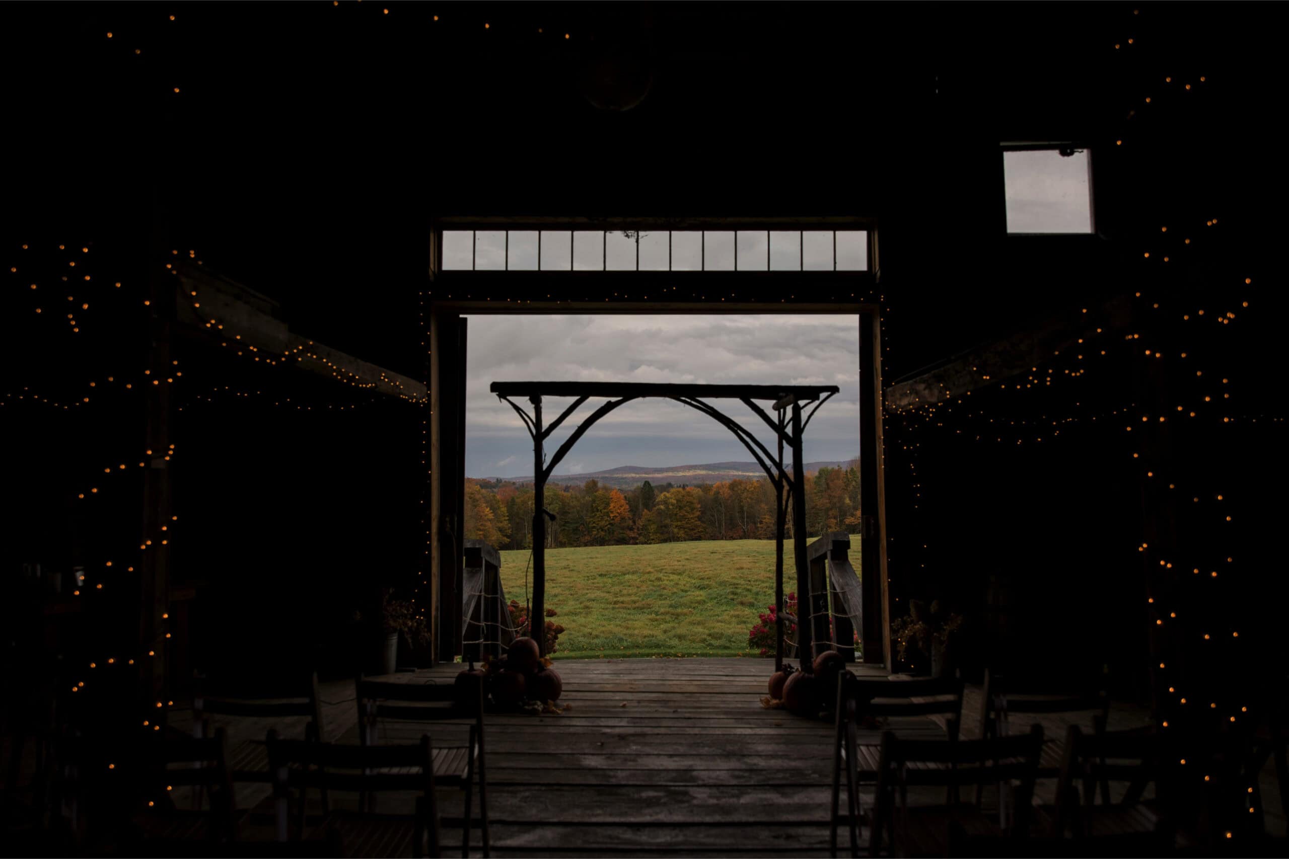 Outdoor wedding venue with scenic landscape and rustic archway.
