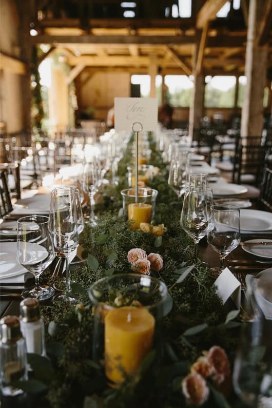Wedding reception table with floral arrangements and candles for elegant events.