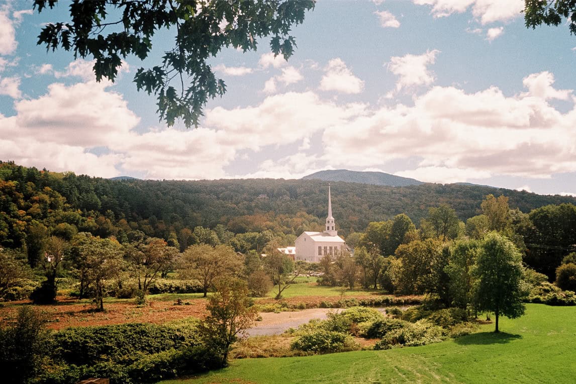 Scenic church venue surrounded by lush greenery and rolling hills, ideal for outdoor weddings and ev.