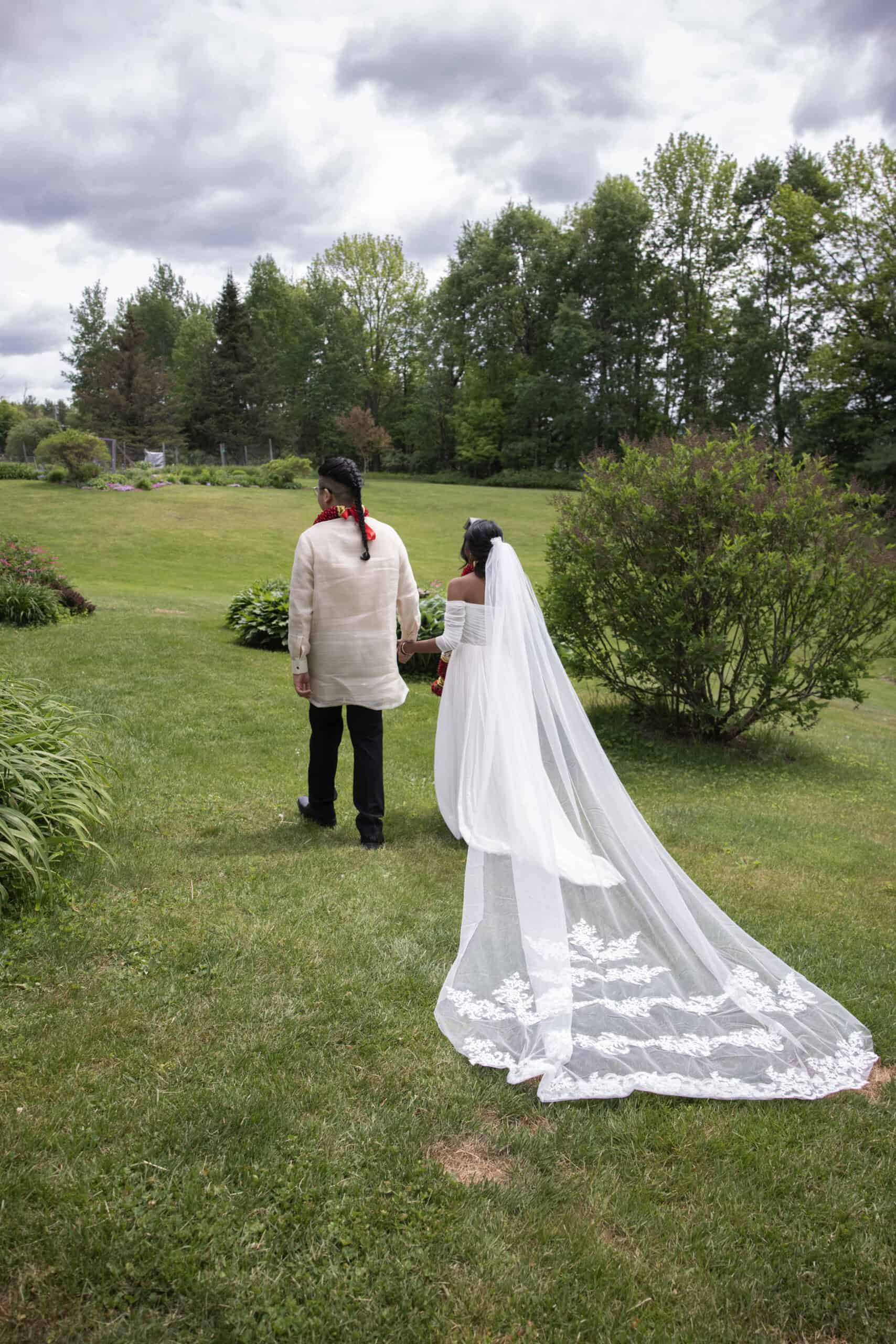 Outdoor wedding ceremony with bride and groom in a scenic garden landscape.