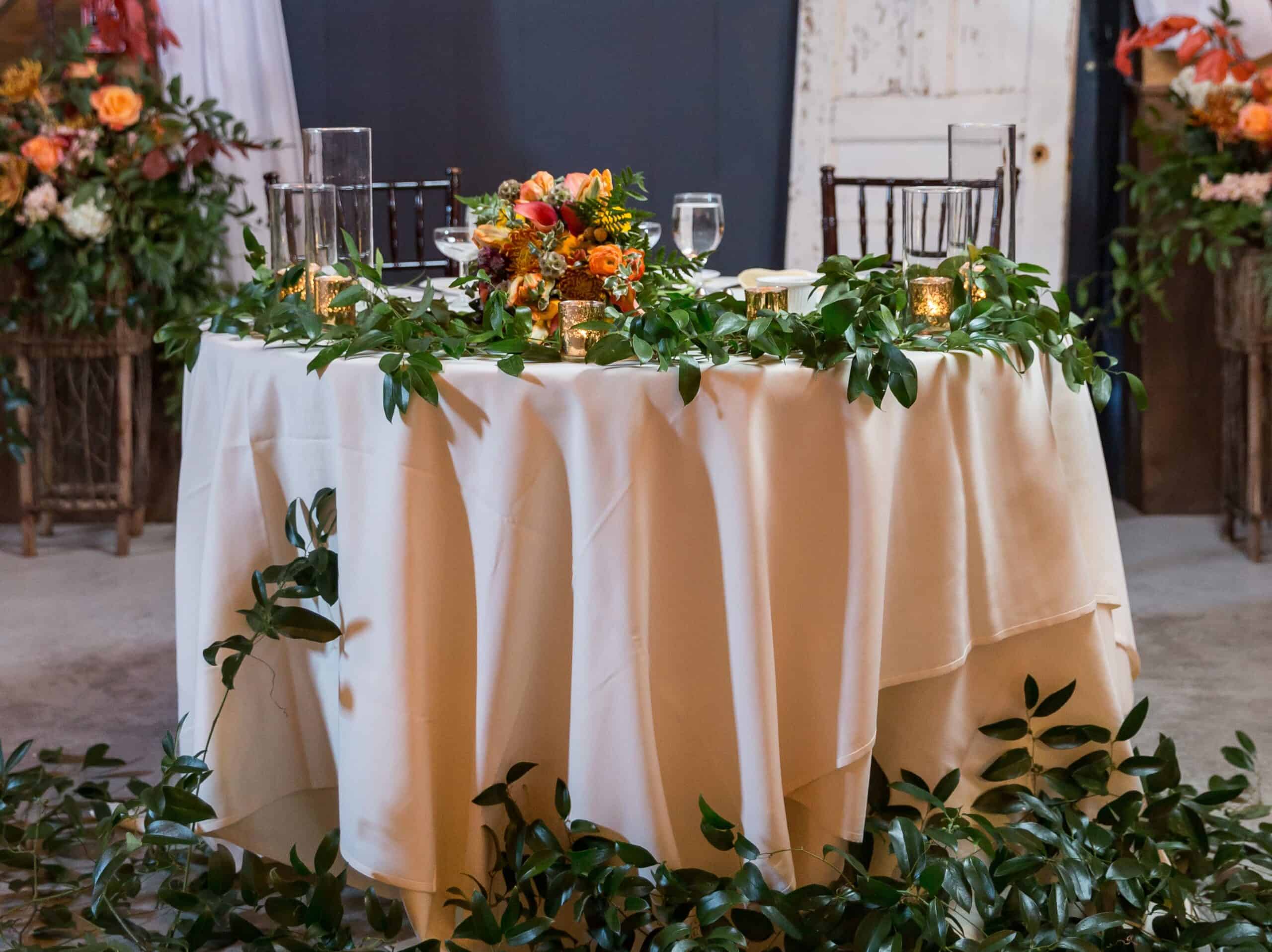 Elegant wedding reception table with floral centerpiece and candlelit decor.