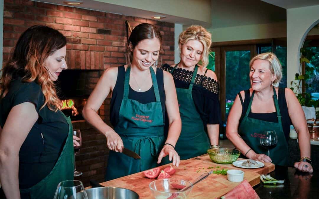 Women cooking together at a cooking class event, showcasing Odyssey Events' team-building and culina.
