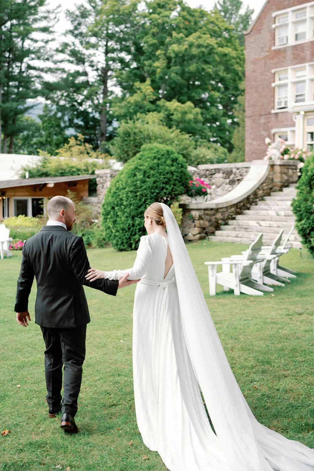 Wedding couple holding hands outdoors at a garden venue, perfect for wedding events and celebrations.