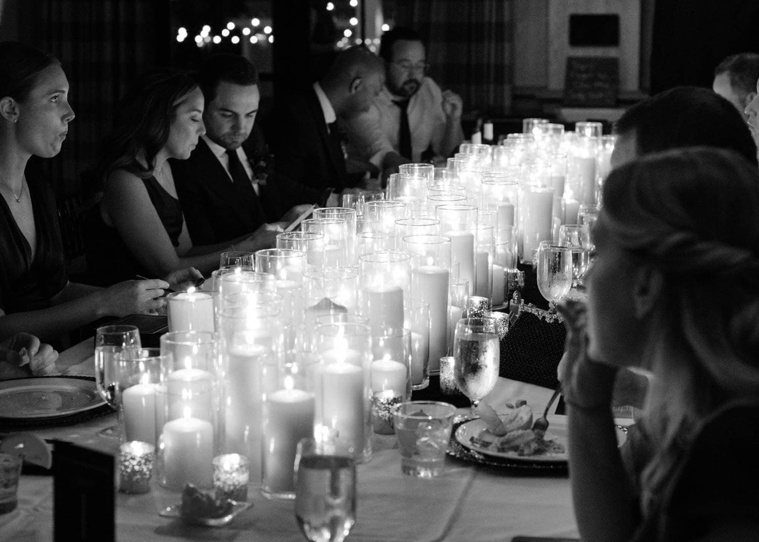 Candlelit dinner with guests at Odyssey Events, featuring a long table with candles creating a warm,.