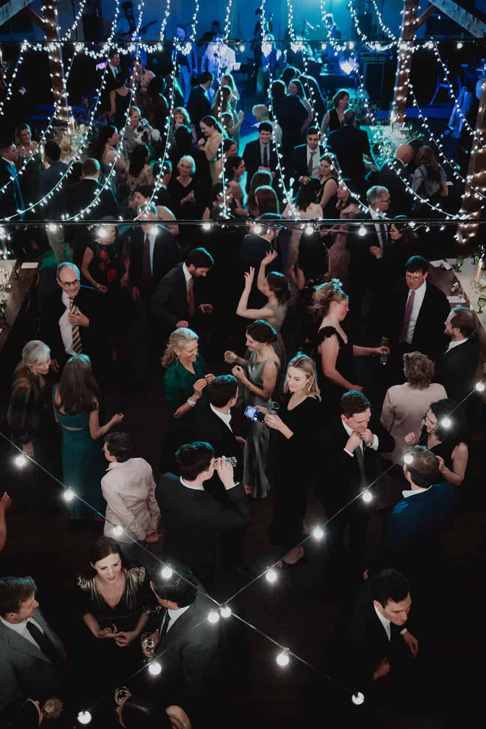 Elegant wedding reception with string lights, guests dancing, and festive atmosphere. Perfect for me.