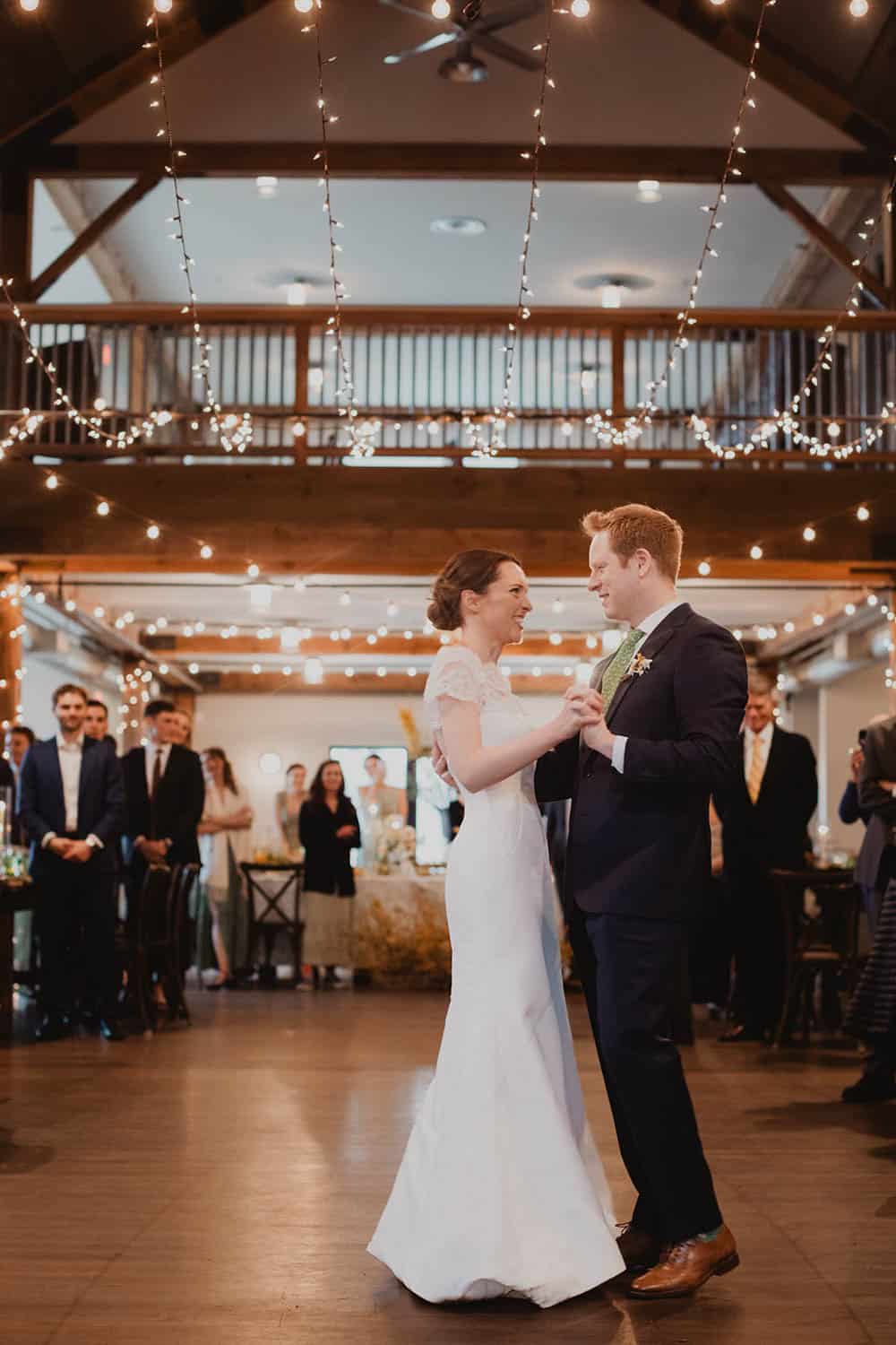 Bride and groom sharing their first dance in a beautifully decorated reception hall.
