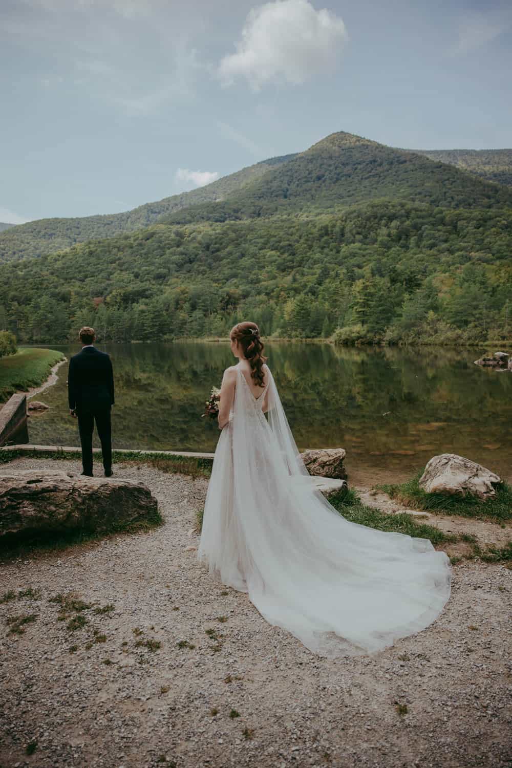 Outdoor wedding ceremony by a mountain lake with lush greenery and scenic views.