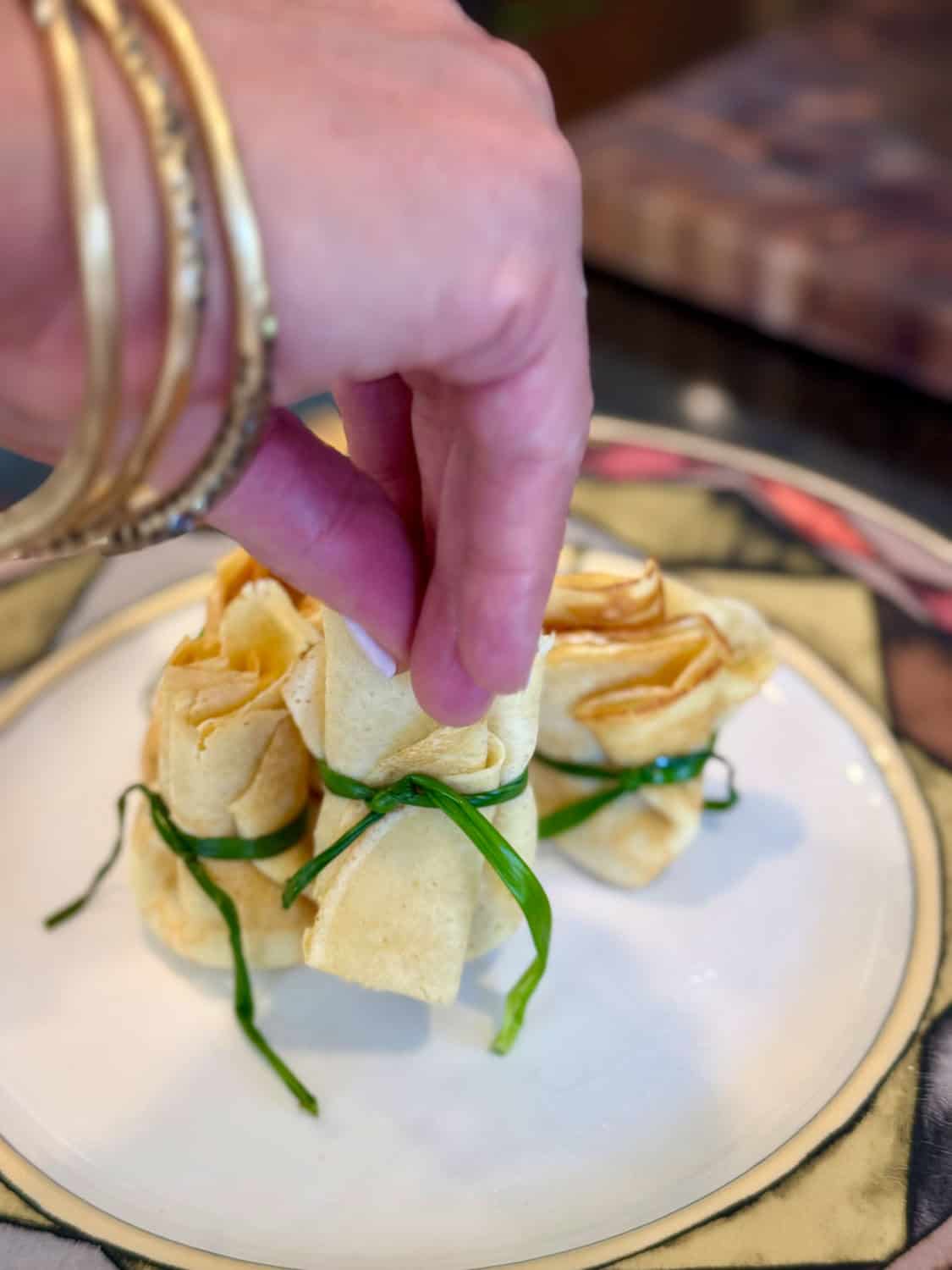 Appetizer wraps tied with green herbs, served at Odyssey Events.