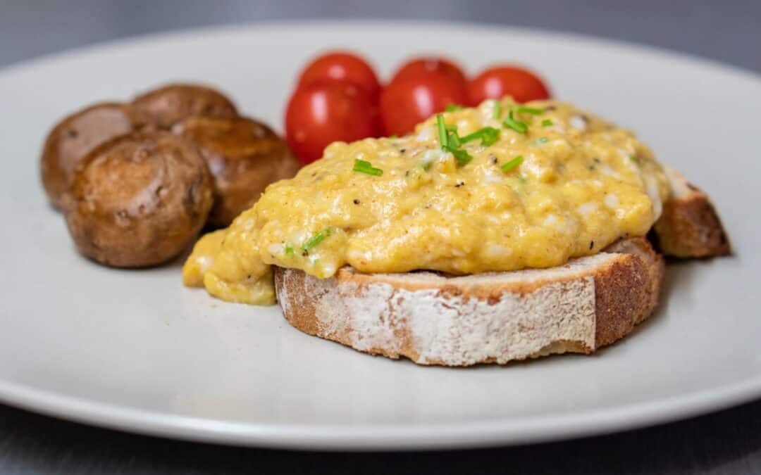 Water Fish with scrambled eggs, cherry tomatoes, and mushrooms on toast.